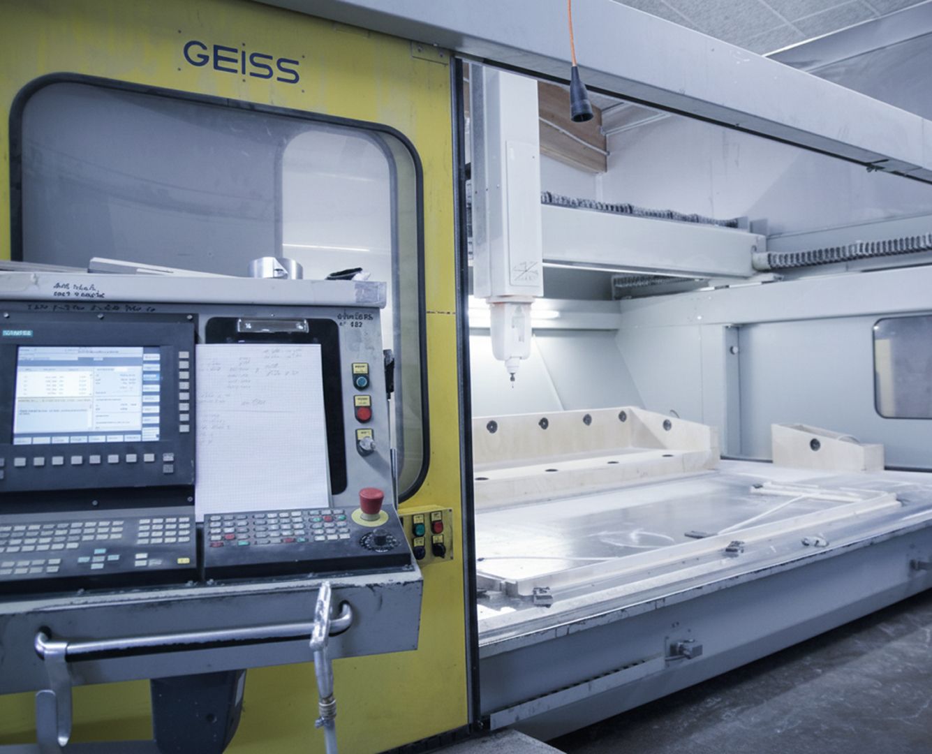 Industrielle CNC-Fräsmaschine mit Steuerungstafel und großem Bearbeitungstisch in einer Werkhalle